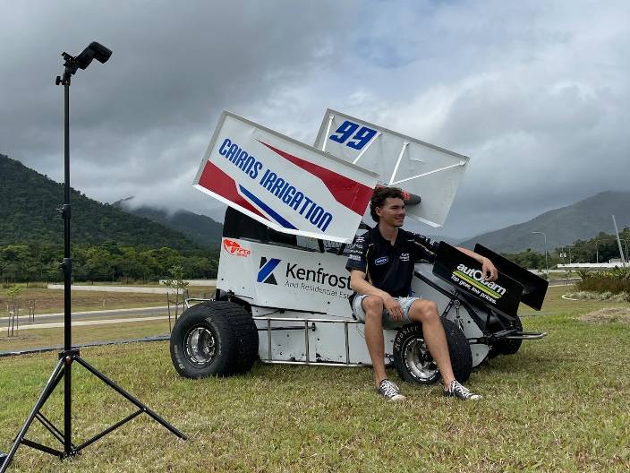 Ash sitting on wheel of racecar