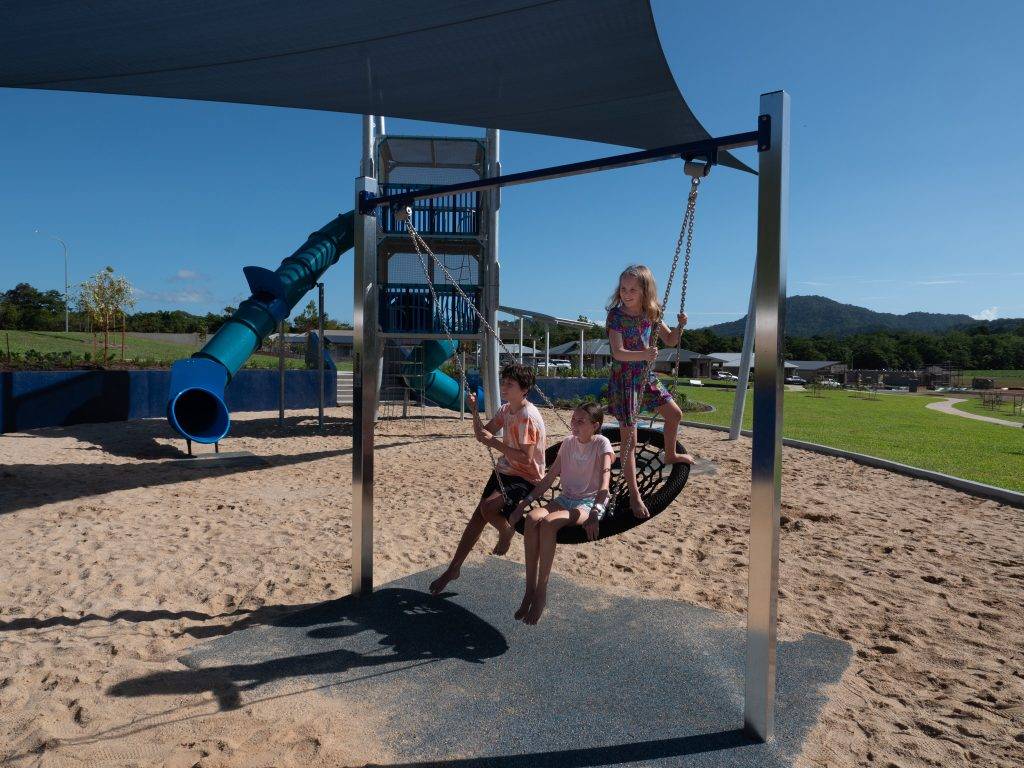 Kids play on the large swing at Vistas at Redlynch playground